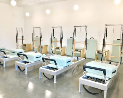 Bright and clean boutique Pilates studio equipped with Reformers, Towers and Pilates chairs