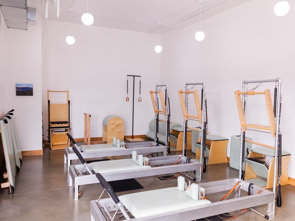Bright and clean boutique Pilates studio equipped with Reformers, Towers and Pilates chairs
